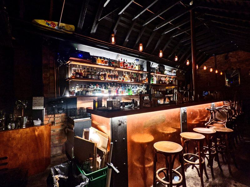 Pendant lights over a bar and back-bar shelving